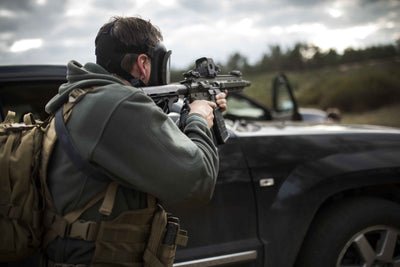 Side view of a man wearing the CM-6M full-face respirator while using a firearm